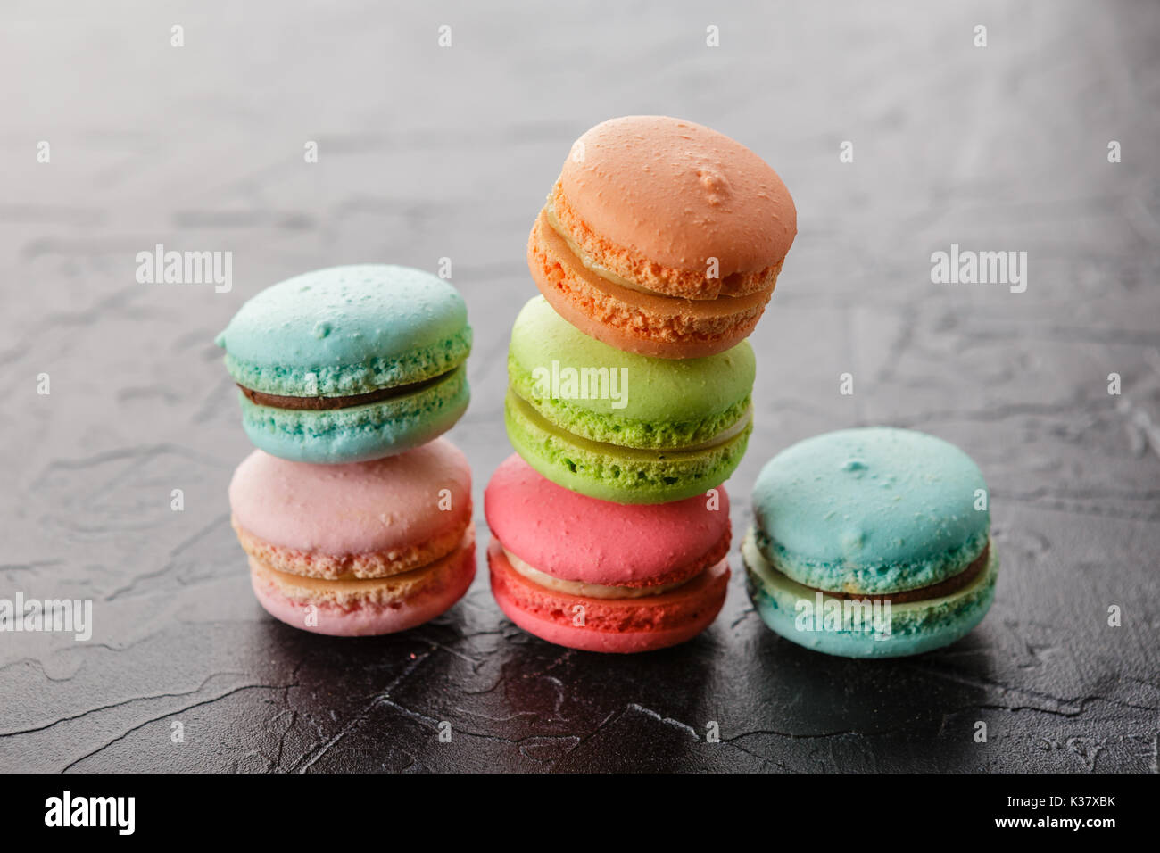 Classica francese amaretto multicolore biscotti nero su sfondo di calcestruzzo Foto Stock