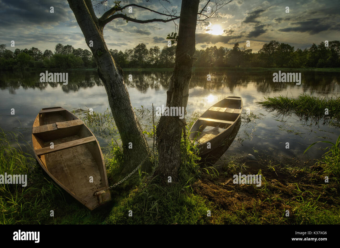 Due barche di legno sul fiume Narew nel tramonto, Polonia Foto Stock