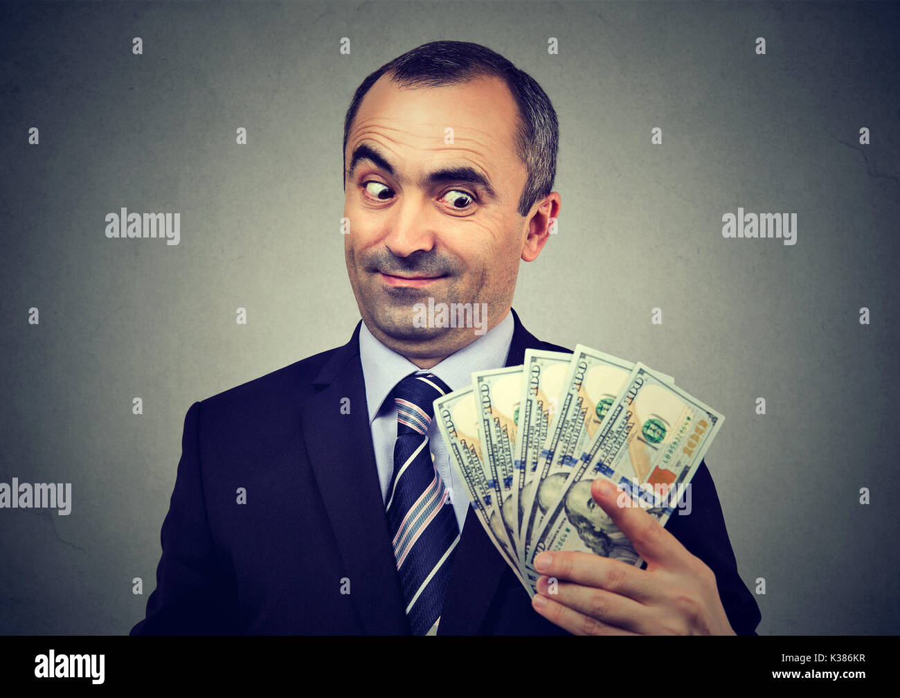 Funny sly business man holding guardando il denaro Foto Stock