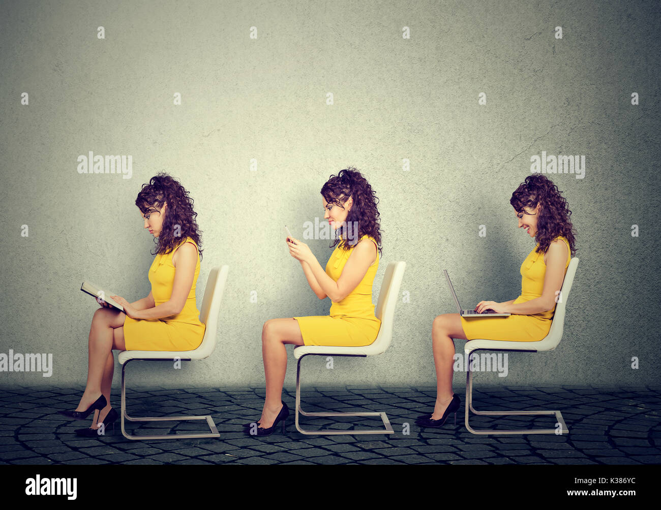 Donna seduta su una sedia la lettura di un libro, scrivere messaggi sul telefono cellulare utilizzando il computer portatile Foto Stock