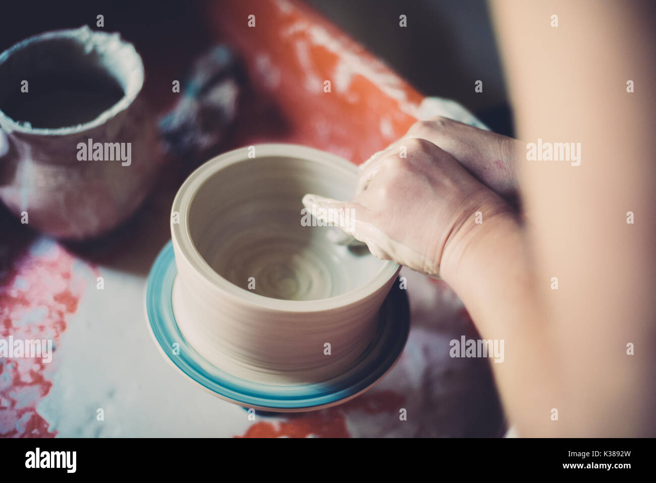 Lavorare in un laboratorio di ceramiche, womans mani creazione di ceramica. Foto Stock