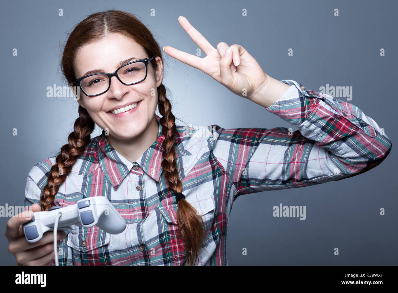 Nerd donna con treccia giocare ai videogiochi con un joypad Foto Stock