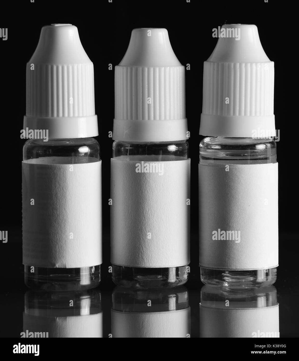 Isolato e bottiglie di liquido per dispositivi vaping, e sigaretta, sigaretta elettronica, su uno sfondo nero. Foto Stock