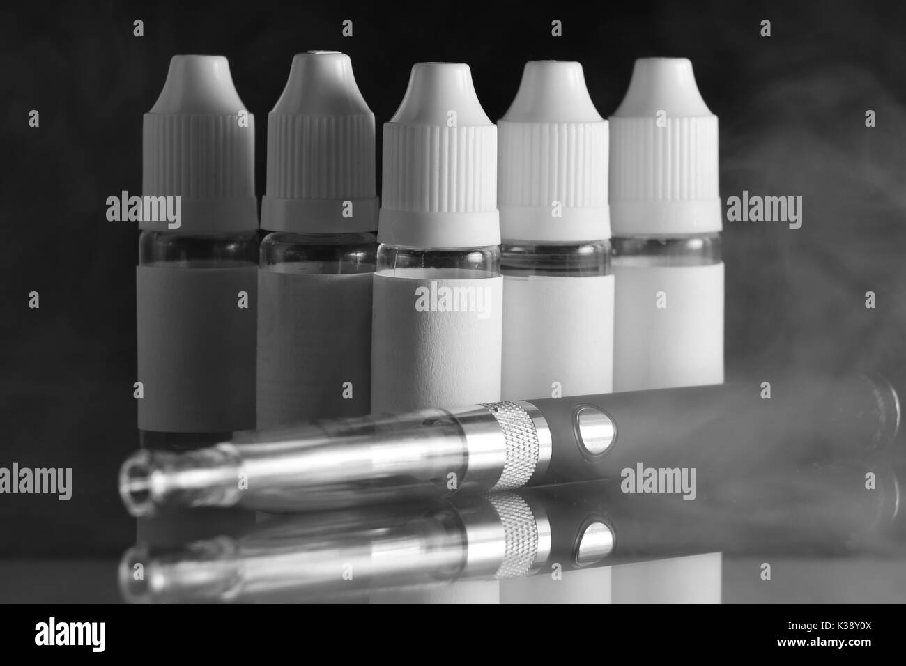 Isolato e bottiglie di liquido per dispositivi vaping, e sigaretta, sigaretta elettronica, su uno sfondo nero. Foto Stock