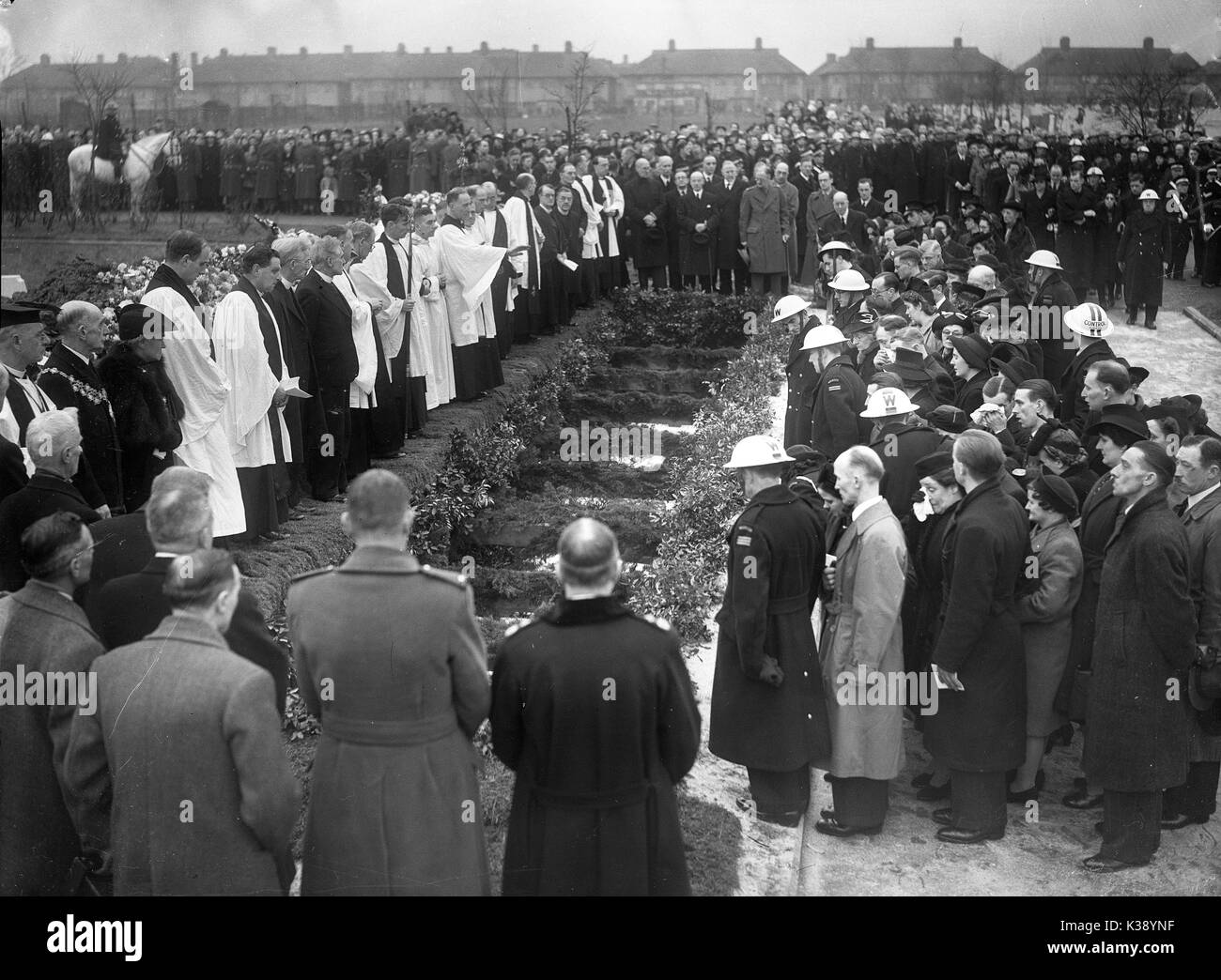 Persone in lutto circondano la tomba di massa come il 44 vittime di un tedesco di bombardamento sono sepolti a qua il cimitero di verde a Londra, la II Guerra Mondiale, 27 gennaio 1943. Trentotto bambini e 6 insegnanti sono stati uccisi quando Sandhurst Road School di Catford, Londra del sud ha preso un colpo diretto quando un Fokker-Wolf Fw 190A-4 è sceso a 1100 lb bomba a 12.30 Mercoledì, 20 gennaio 1943. Foto Stock