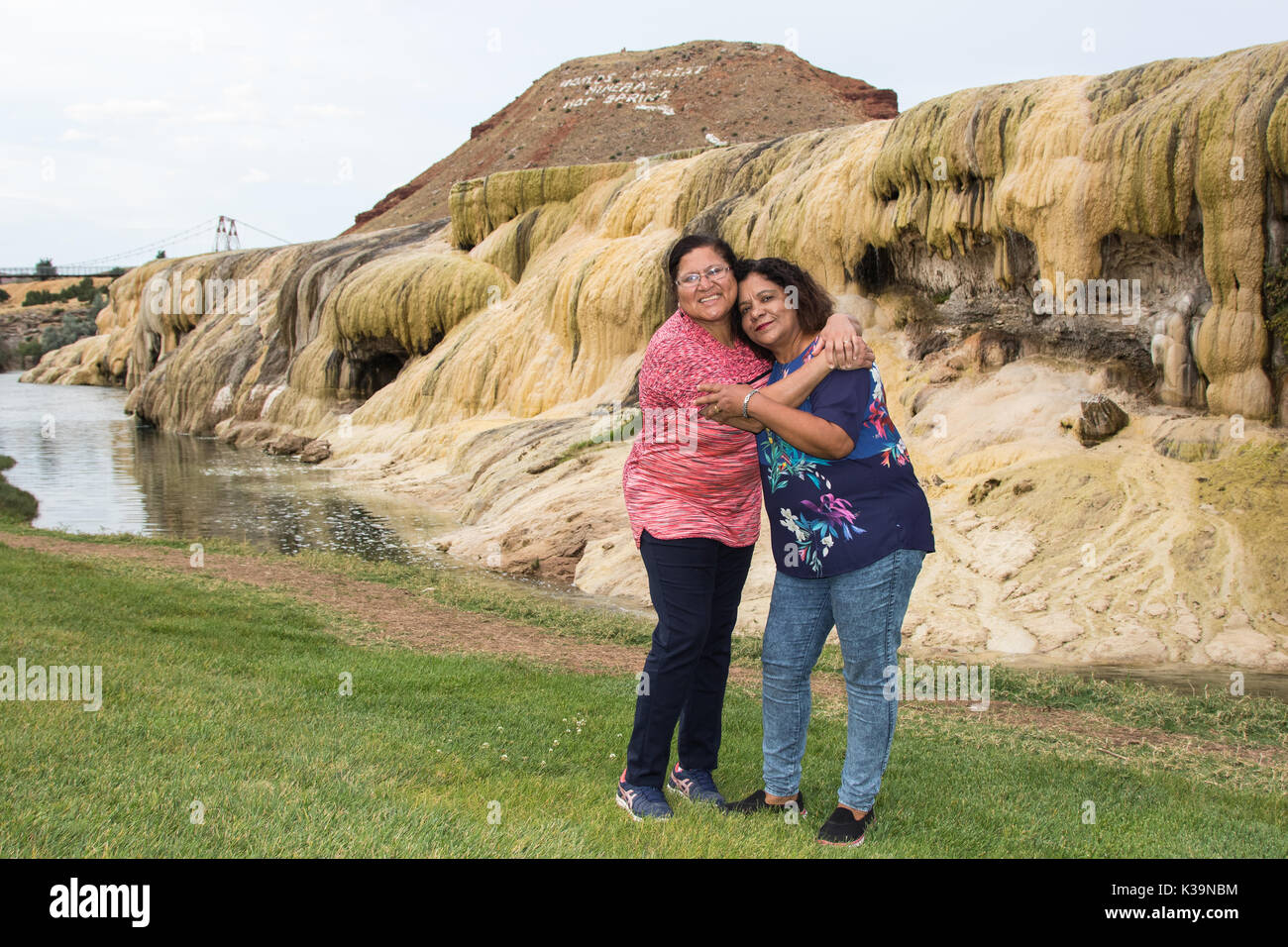 Due donne asiatiche in posa da una terrazza geotermica in Hot Springs State Park, Thermopolis, WY Foto Stock