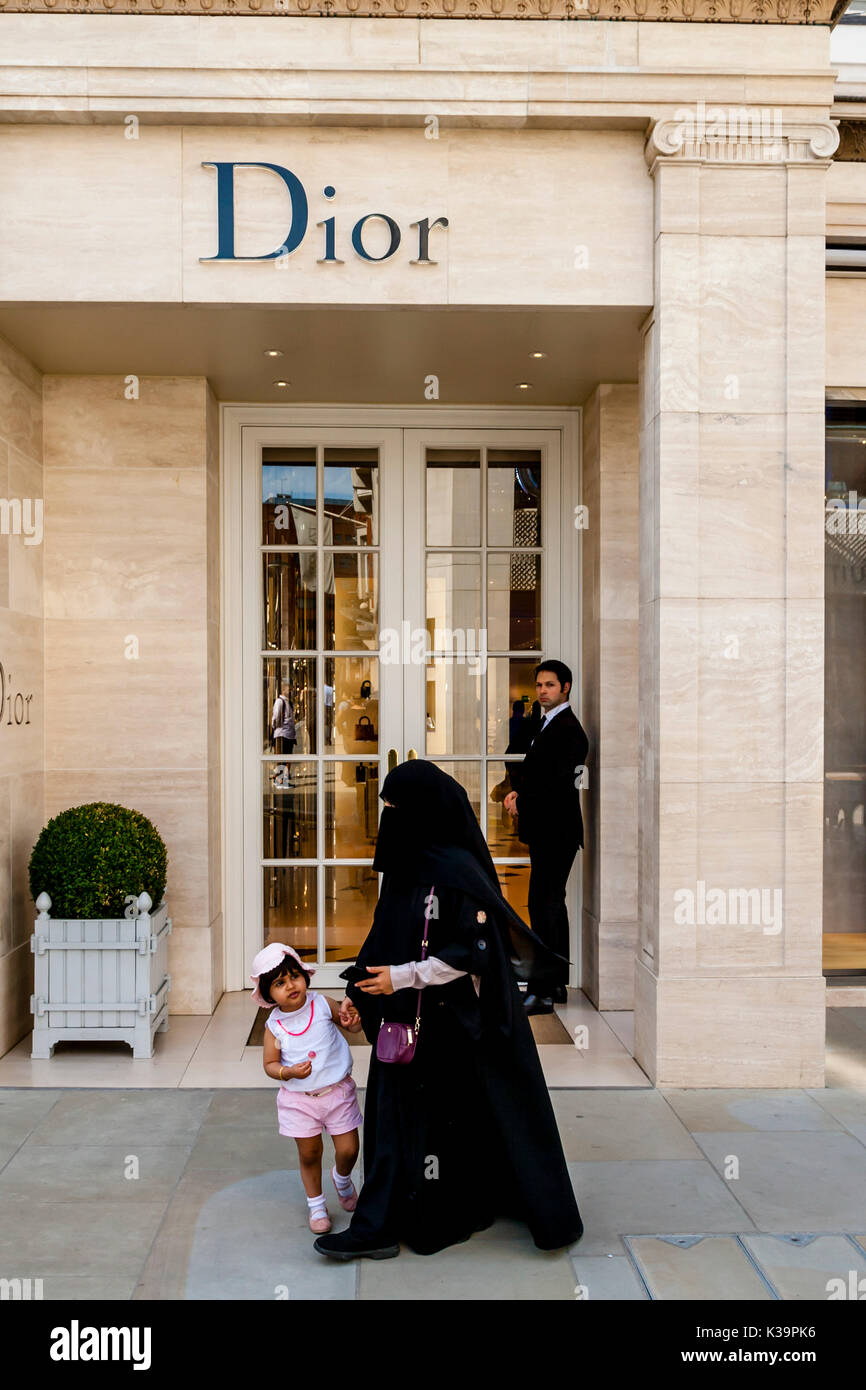 Una donna musulmana di indossare il burka passeggiate passato la Dior Fashion Store In New Bond Street, Londra, Regno Unito Foto Stock