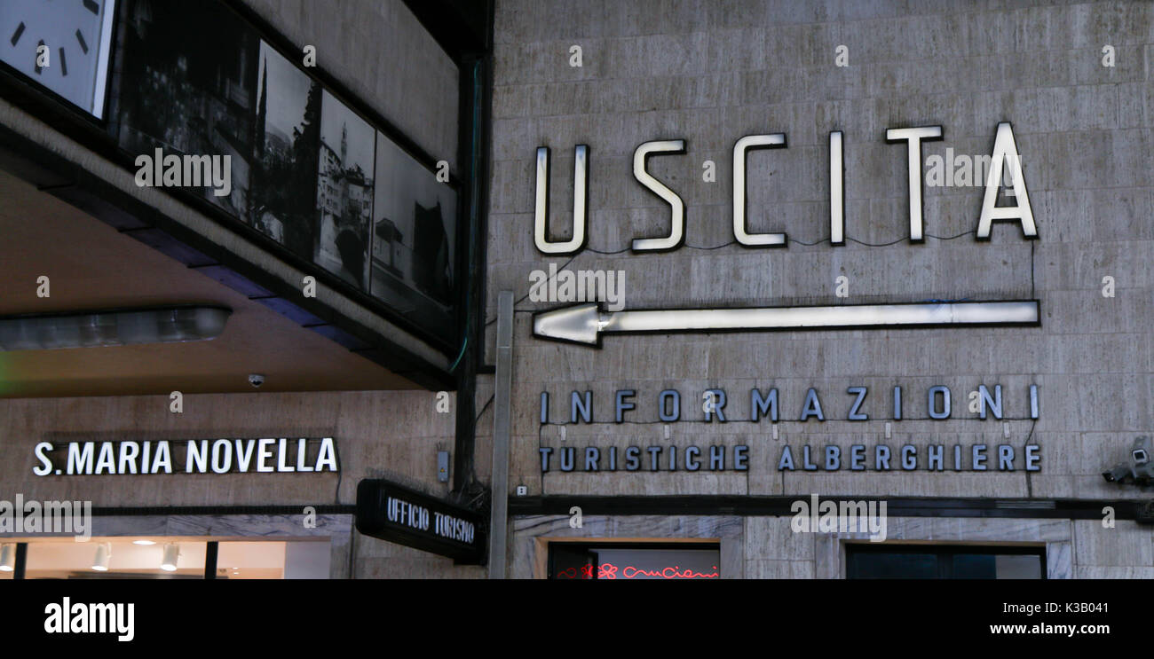 Illuminato in uscita segno nella stazione Firenze Santa Maria Novella (S. Maria Novella). La freccia rivolta verso l'uscita. Le pareti in calcestruzzo. Foto Stock