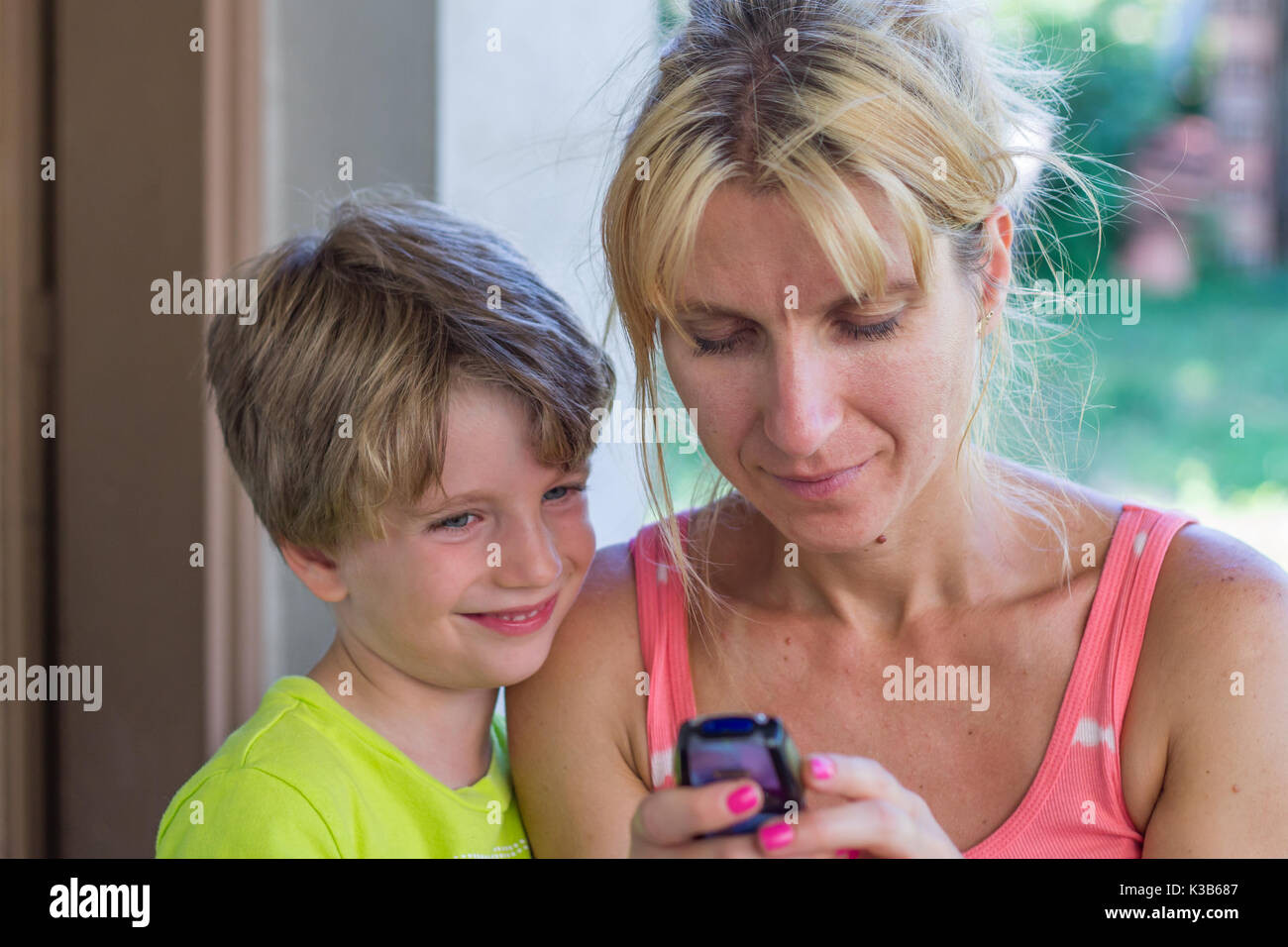 La madre e il bambino guardando un telefono Foto Stock