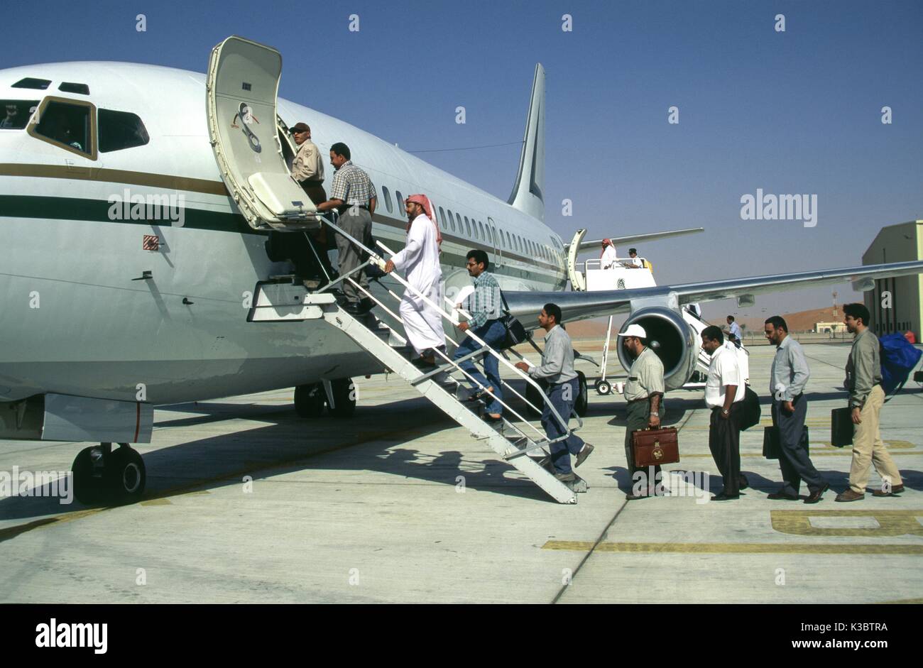 Saudi Aramco dipendenti pensione la Saudi Aramco 737 società piano a Shaybah aeroporto, dopo aver completato il loro lavoro duty tour presso il Gas Shaybah olio impianto di separazione (GOSP), una grande produzione di gas e petrolio stabilimento situato nel quartiere vuoto deserto di Arabia Saudita, vicino al confine degli EMIRATI ARABI UNITI. Foto Stock