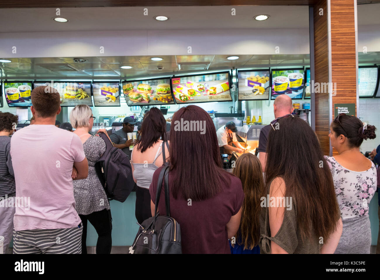 Code di persone a McDonald's Ashford Designer Outlet Center Kent shopping mall. In coda per il cibo Foto Stock