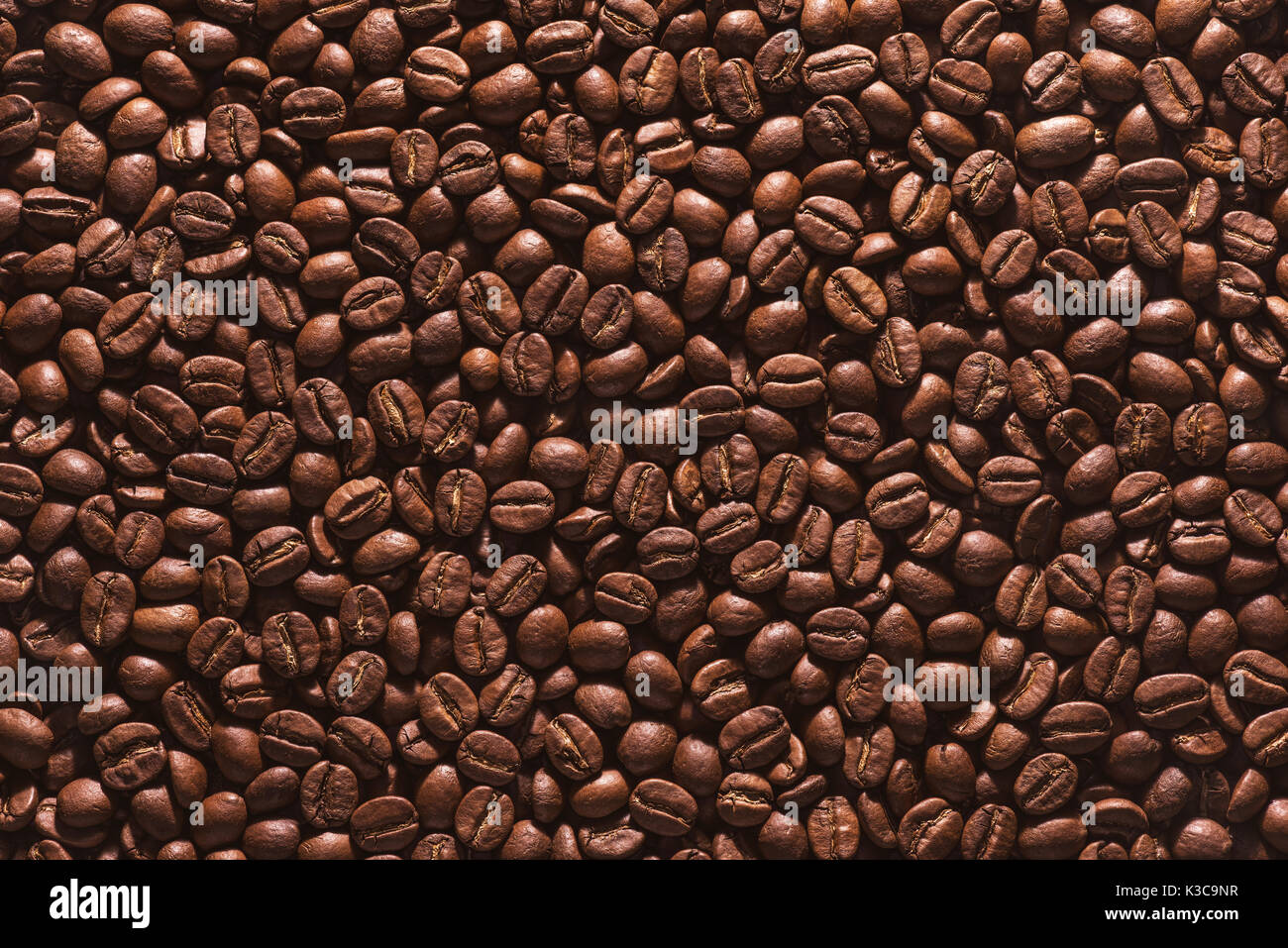 Chicchi di caffè tostati su uno sfondo piatto. Foto Stock