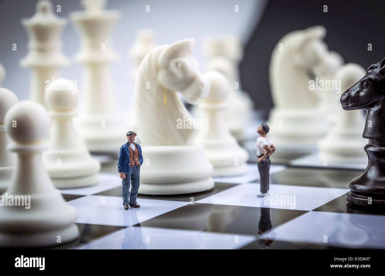 Gli uomini miniatura all'interno di un gioco di scacchi, concept Foto Stock