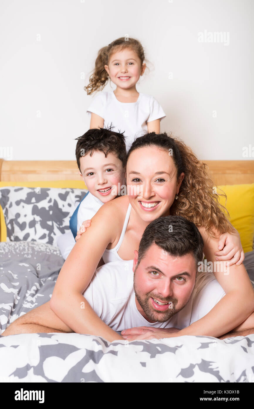 Famiglia i bambini e home concetto - happy Family con due bambini sotto coperta a casa Foto Stock