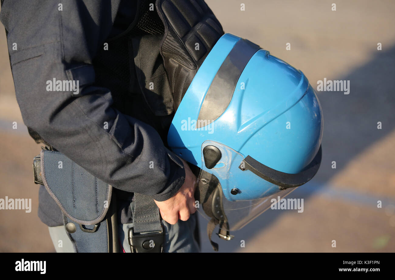 Casco Blu di un poliziotto con uniforme durante una sommossa in città Foto Stock