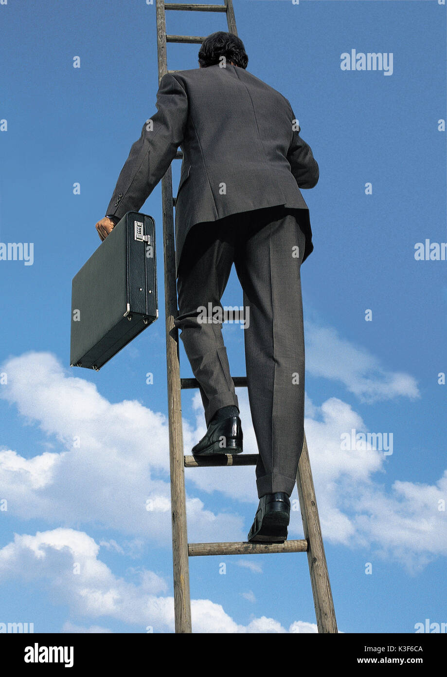 Uomo con valigetta pioli salite su una scala Foto Stock