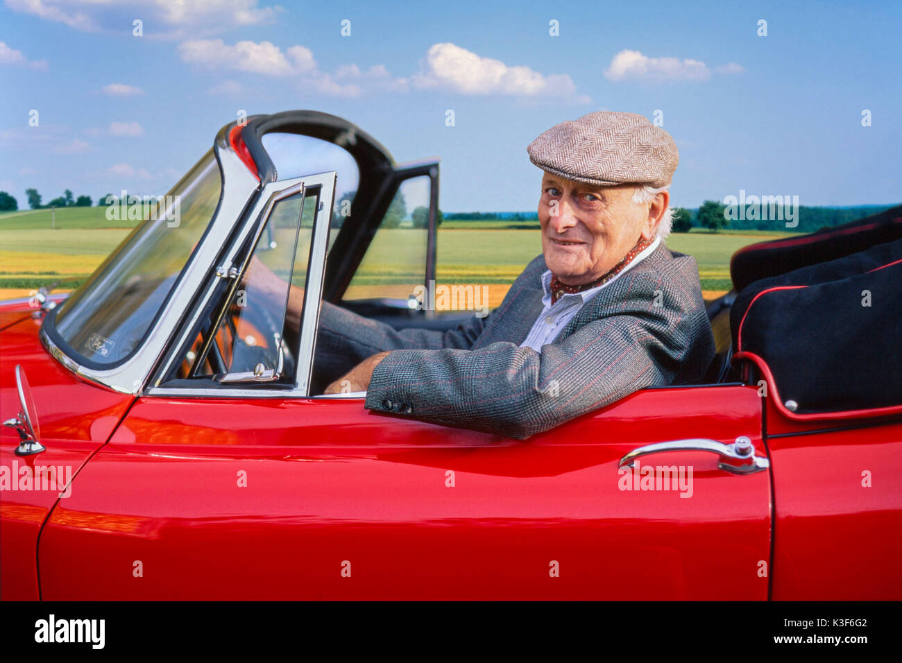 Affluente Senior in rosso old-timer Jaguar XK 150 cabriolet Foto Stock