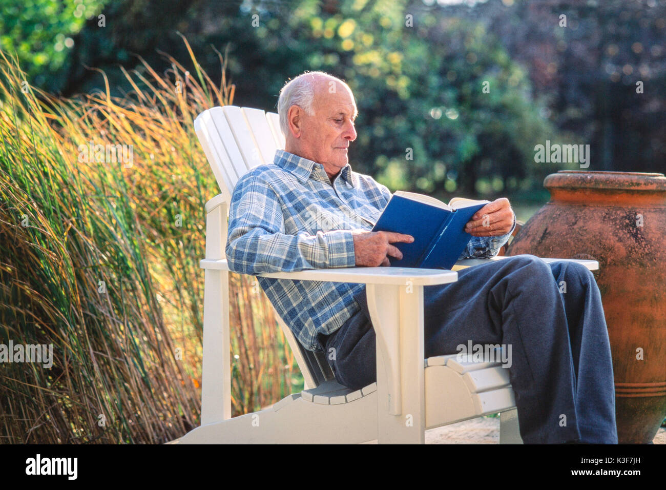 Senior letture in giardino Foto Stock