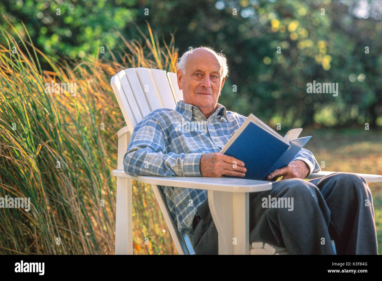 Senior letture in giardino Foto Stock