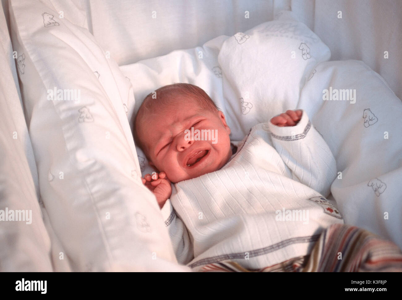 Gridando bambino presso il lettino per il bambino Foto Stock