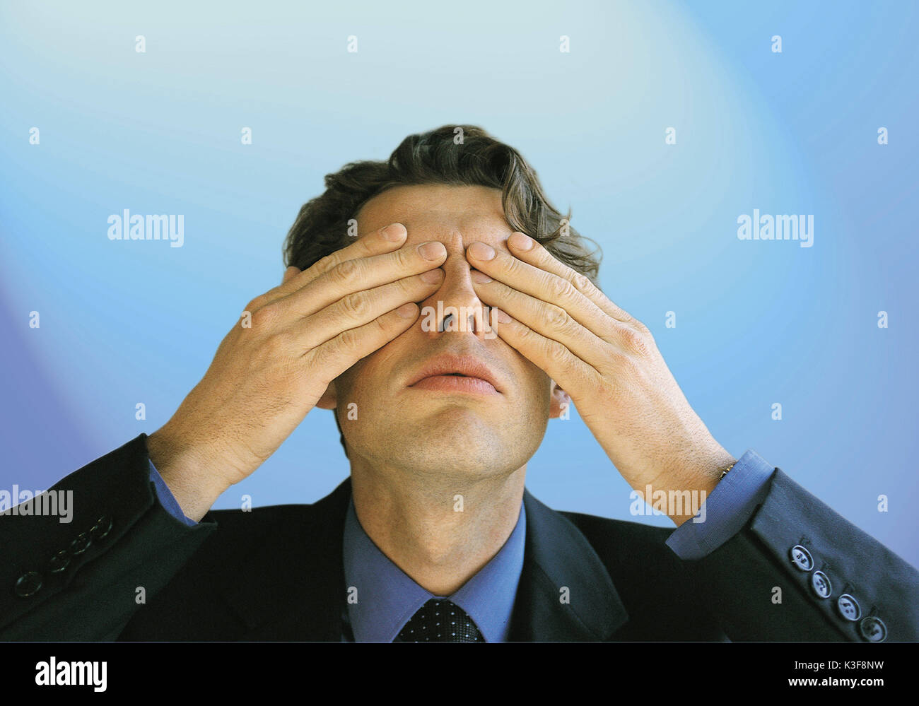 L'uomo copre gli occhi con le mani Foto Stock