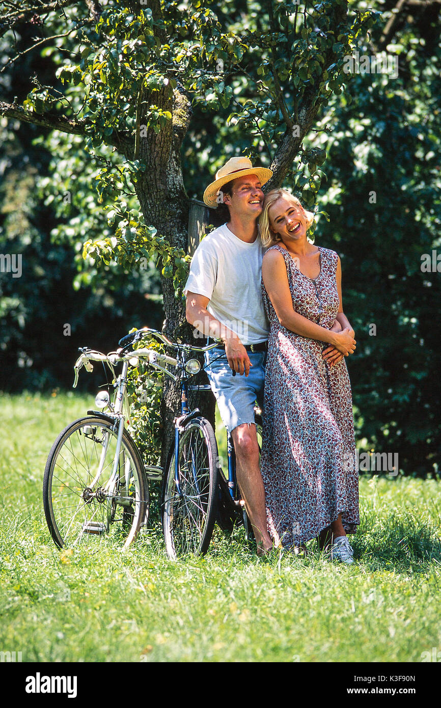 Matura in amore si appoggia in una struttura ad albero Foto Stock