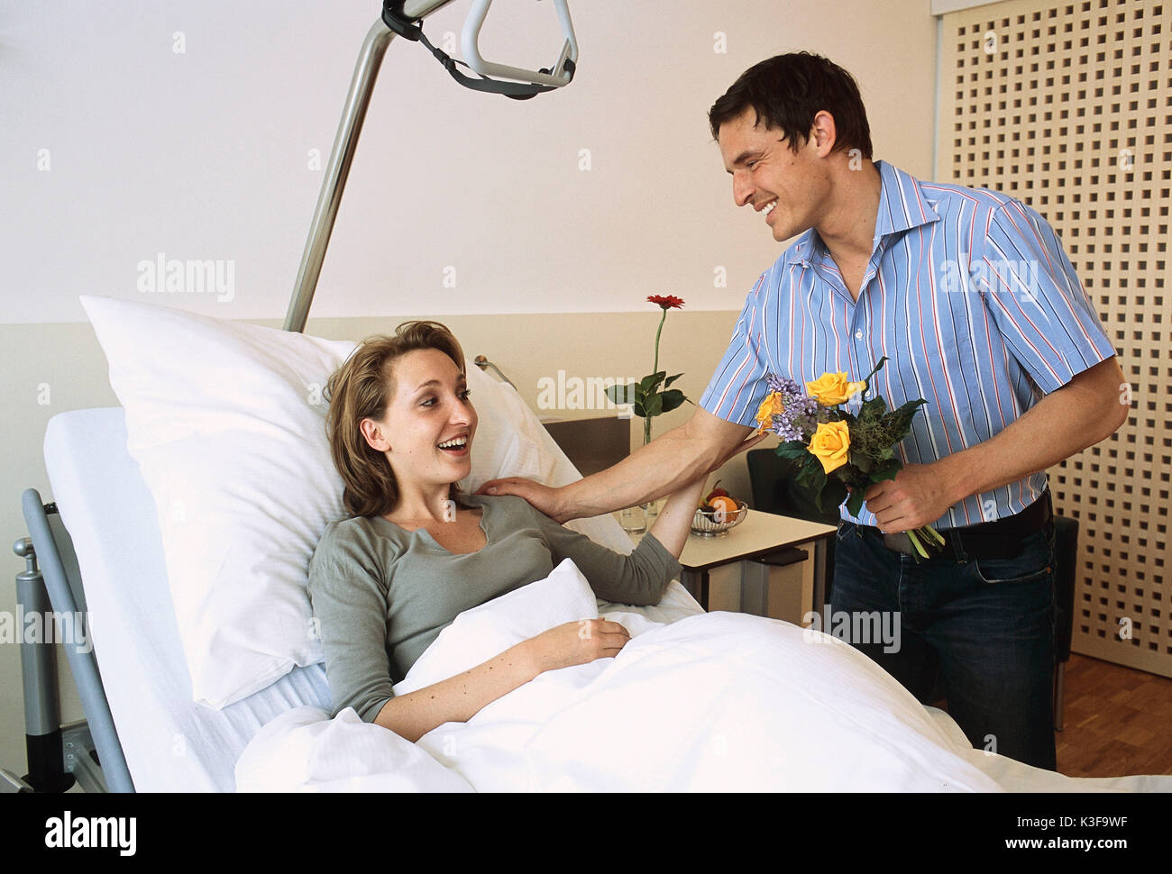 Giovane uomo frequenta la donna in ospedale Foto Stock