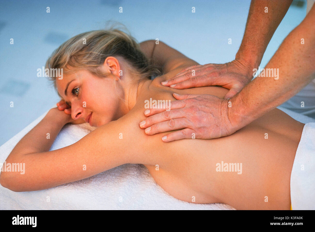Massaggio della schiena a una giovane donna Foto Stock