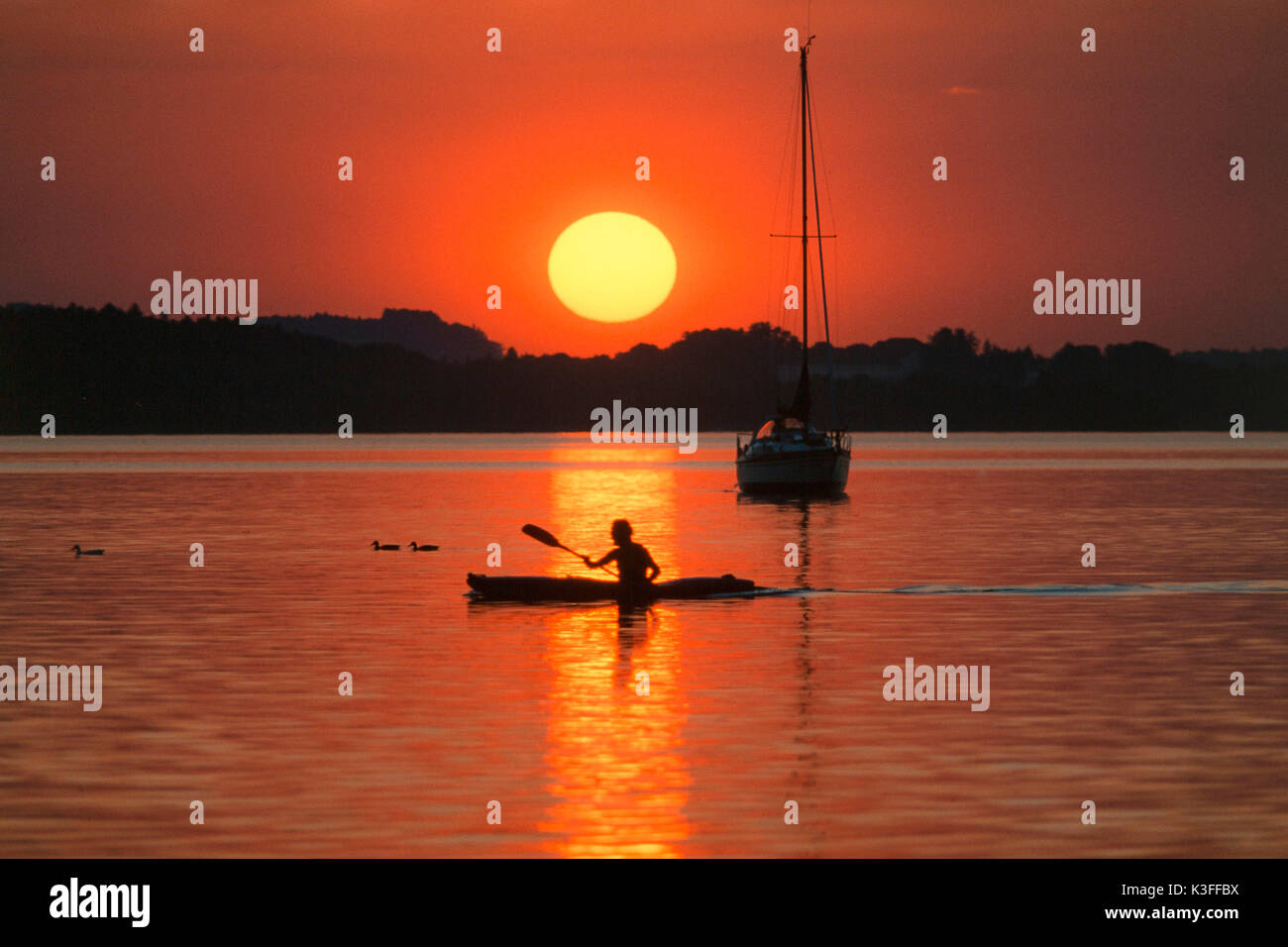 Kayakist davanti al tramonto in Ammersee Foto Stock