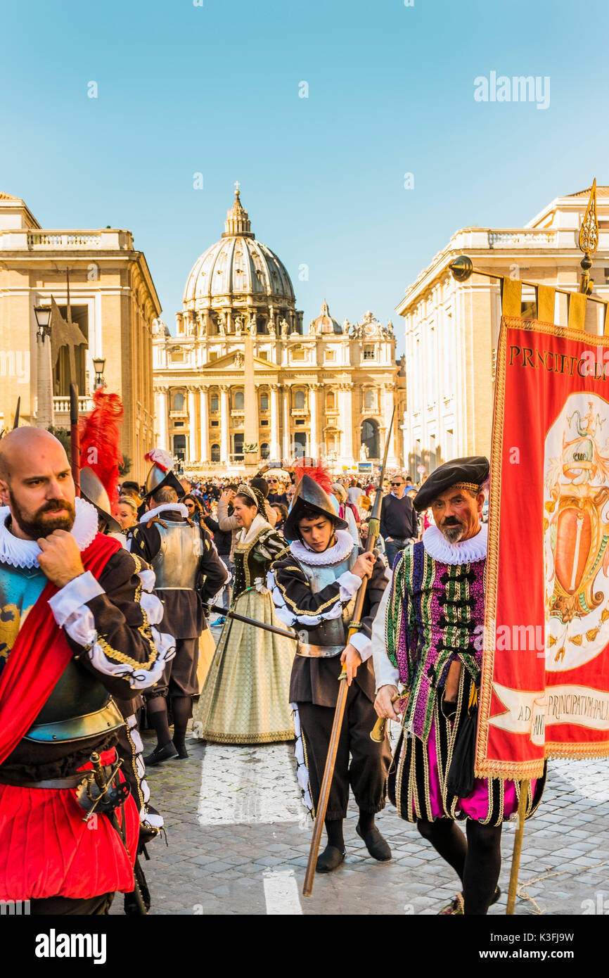 Membri della rievocazione storica gruppo in costumi rinascimentali durante una parata, basilica di San Pietro in background Foto Stock