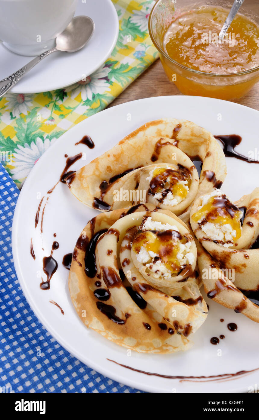 Pancake piegato nella forma di una lumaca per la ricotta con il cioccolato Foto Stock