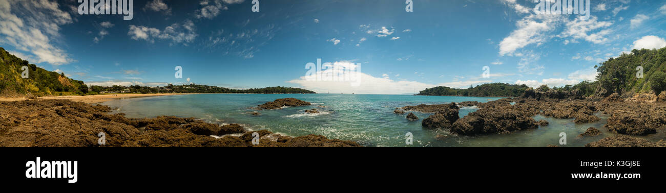 Panorama di una spiaggia di sabbia con pietre vulcaniche e il mare turchese in Nuova Zelanda Foto Stock