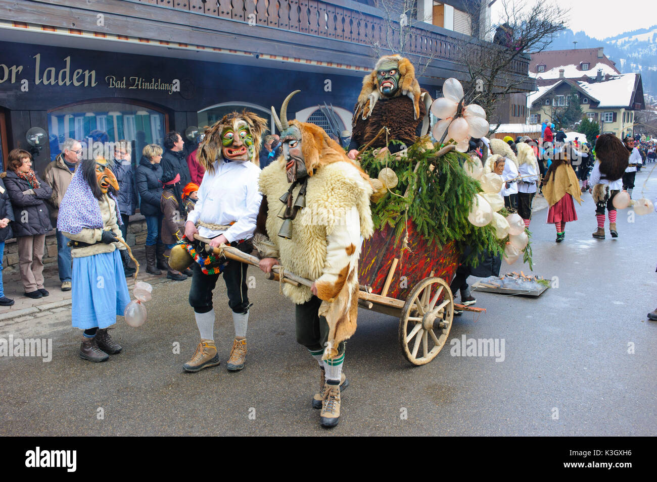 Sfilata di Carnevale sulla strada alta di Bad Hindelang su domenica di carnevale con molti storico artistico maschere in legno Foto Stock