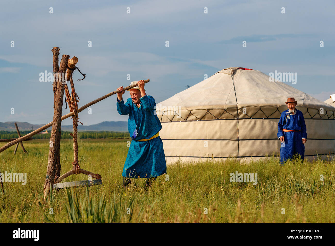 Mongolia Interna, China-July 26, 2017: tradizionalmente vestito vecchio mongola processo gli uomini la pelliccia di pecore in un modo tradizionale per ulteriori lavori di cuoio. Foto Stock