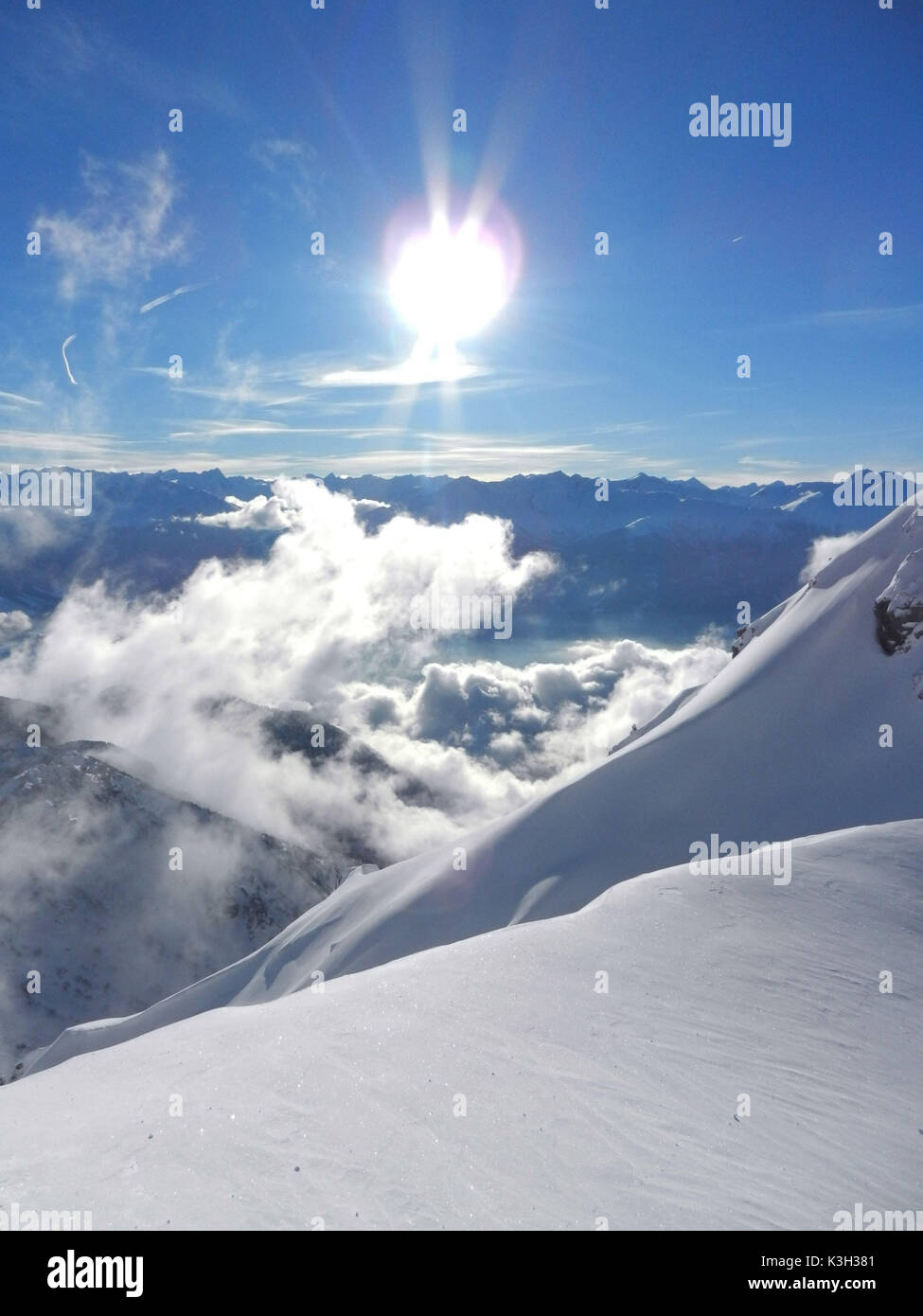 Vista dalla Kuhlochscharte invernale oltre l'Inntal sulle Alpi dello Stubai, luce posteriore, cloud gioco, Foto Stock