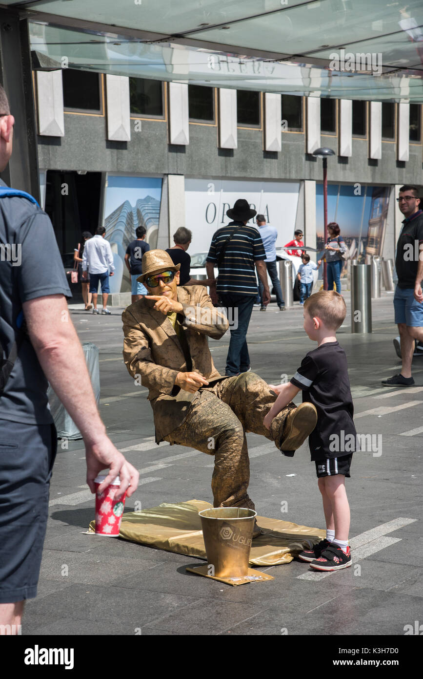 SYDNEY,NSW, Australia-NOVEMBRE 20,2016: oro rifiniti illusionista suonatore ambulante di strada con la gente al Circular Quay a Sydney in Australia Foto Stock