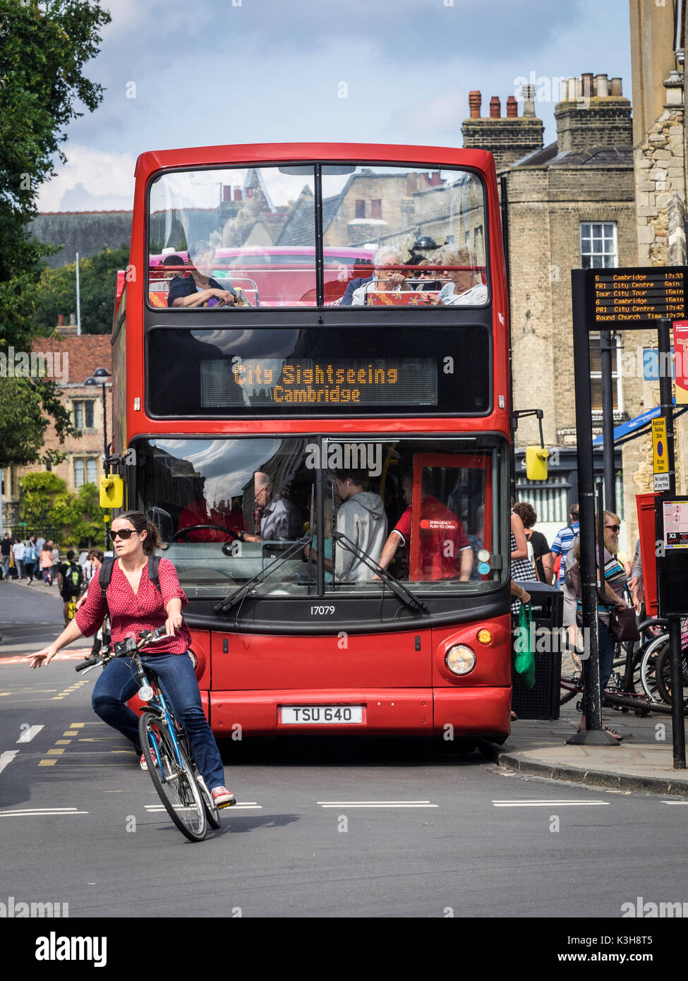 Cambridge Turismo - un ciclista gira nella parte anteriore di un Cambridge Open Top Bus Turistici Foto Stock