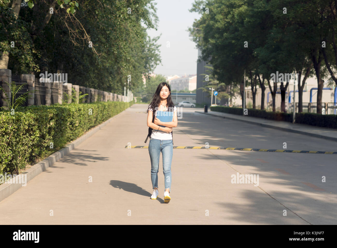 Girl Borsa passeggiate nel parco del campus Foto Stock