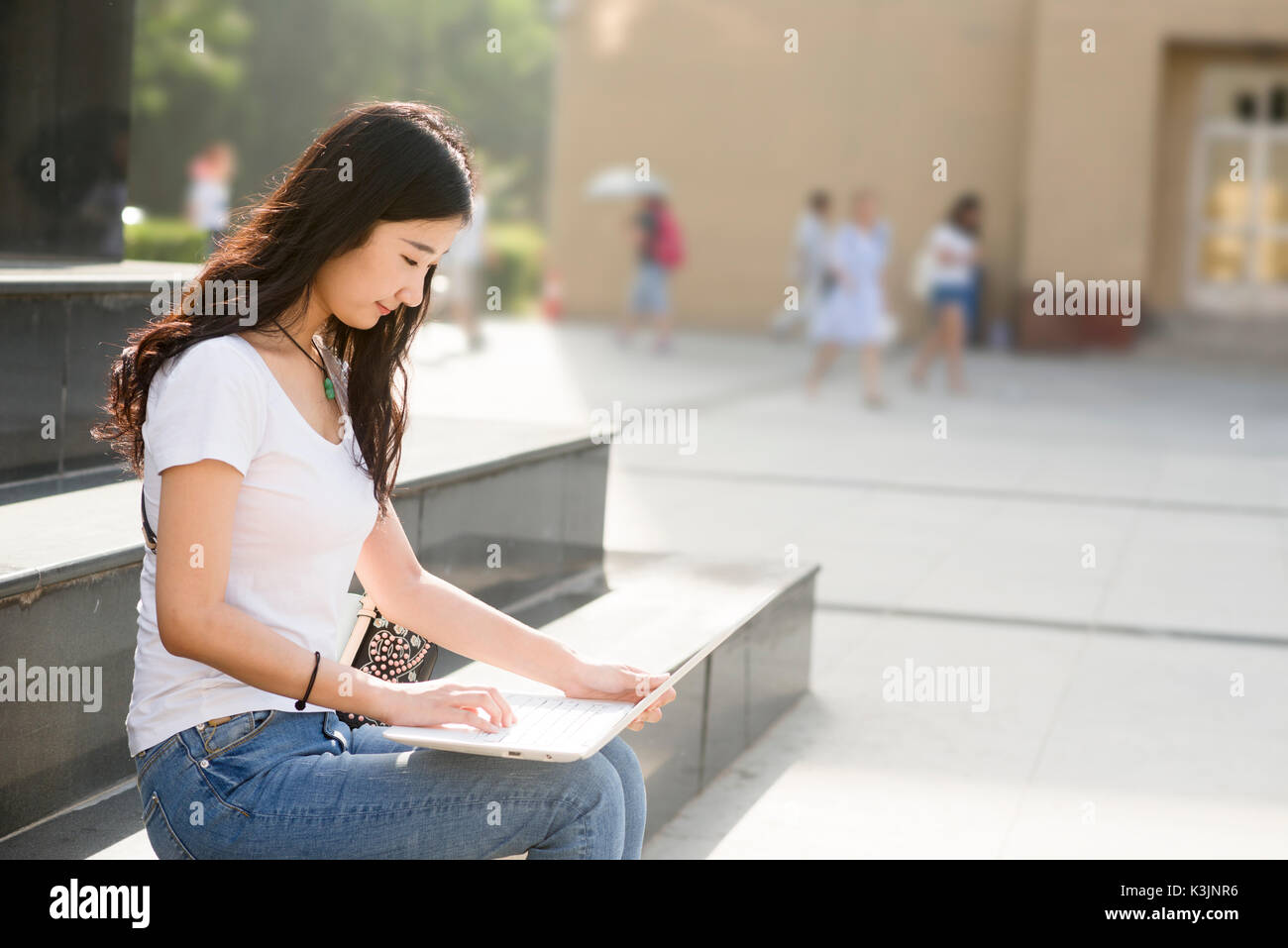 Bella asiatica studente di college con il computer portatile ,seduti sui gradini. Foto Stock