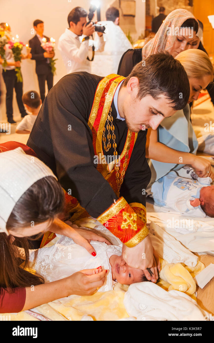 Inghilterra, Londra, Città, Bishopsgate, St.Nicholas Chiesa Ortodossa, battesimale e primo taglio di capelli cerimonia, sacerdote ortodosso Baby di taglio dei capelli Foto Stock