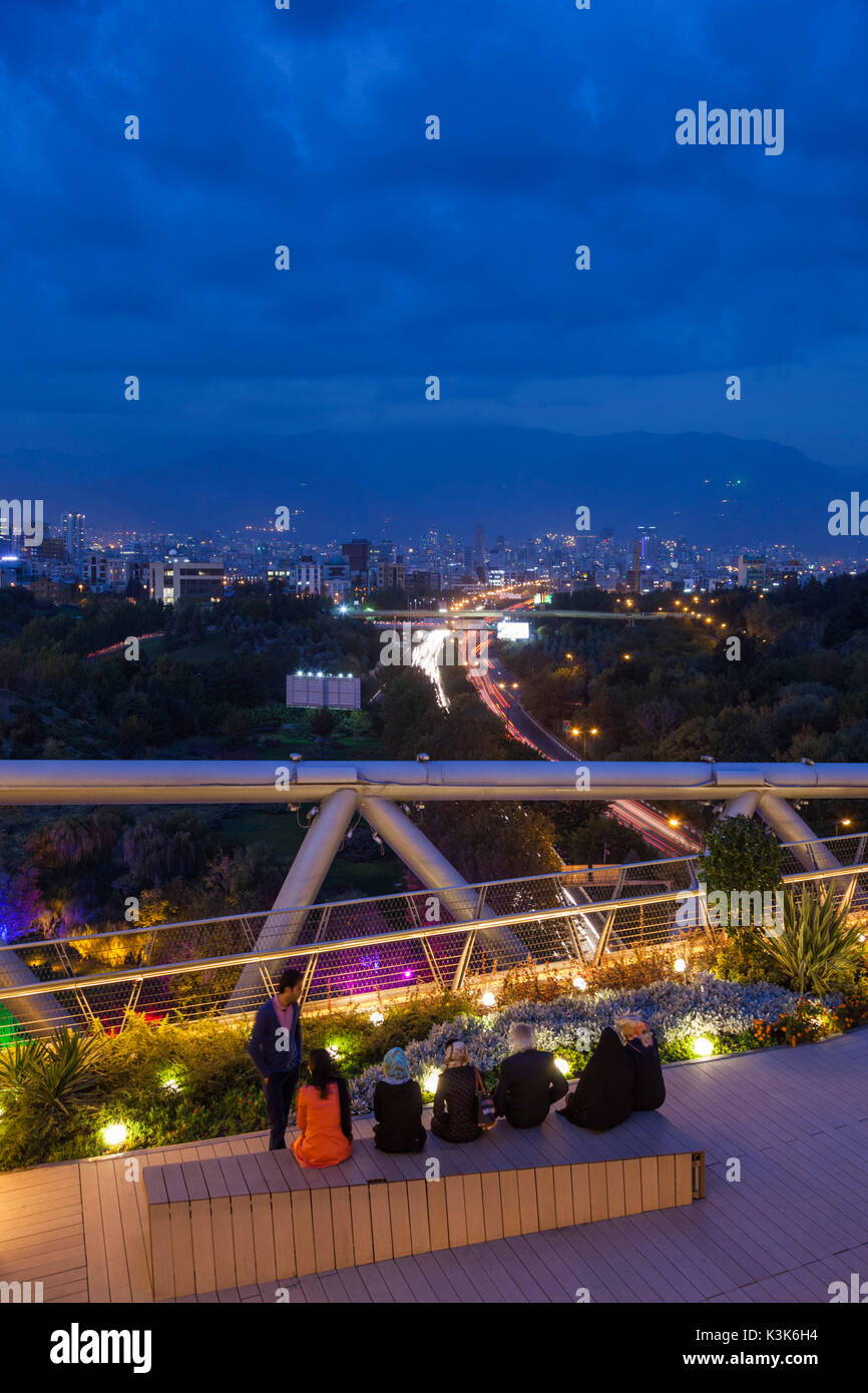 Iran, Teheran dello skyline della città dalla Pole e natura Tabiat Bridge, progettato dall architetto Canadian-Iranian Leila Araghian, costruito nel 2014, crepuscolo, visitatori Foto Stock