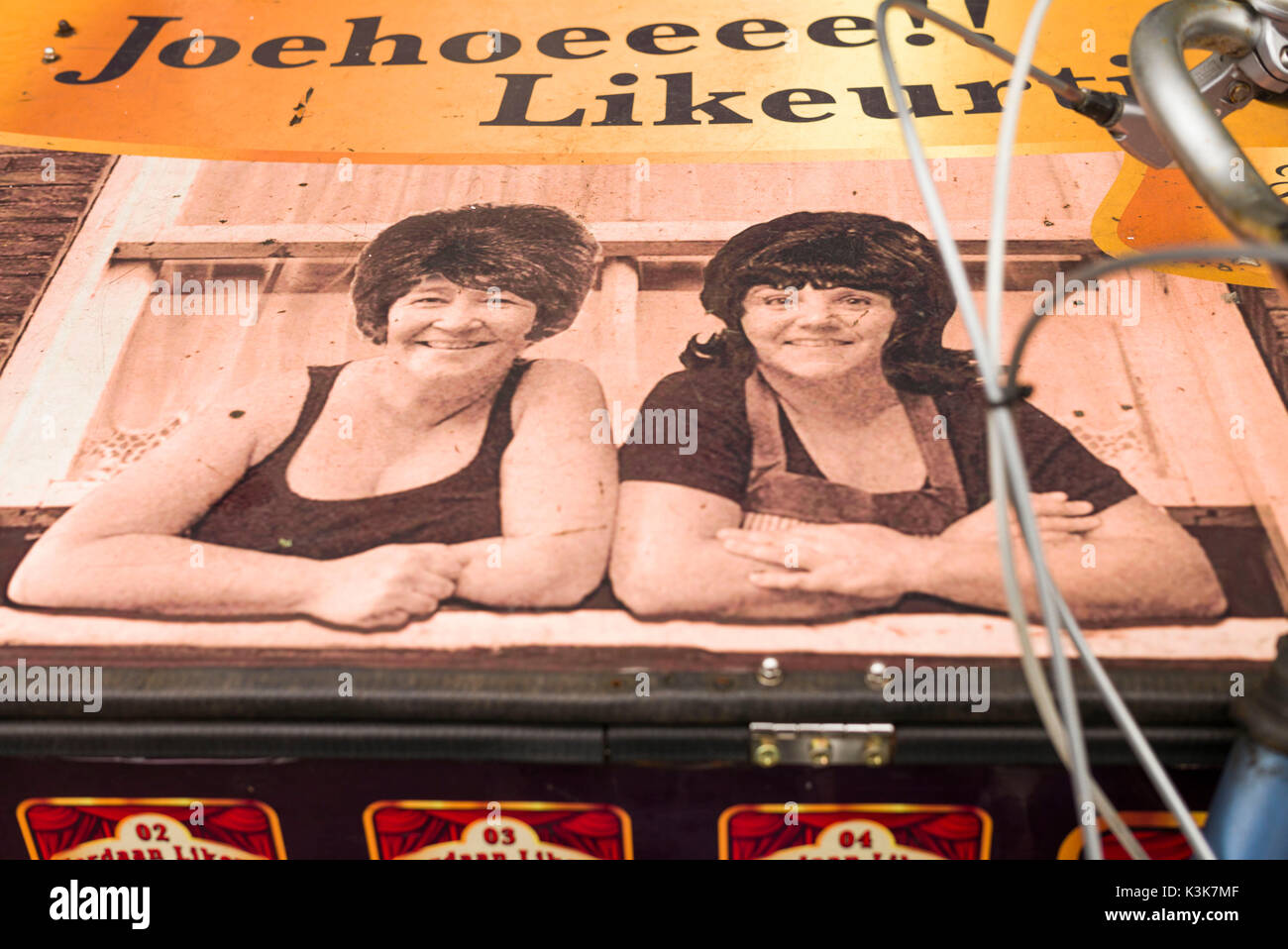 Paesi Bassi, Amsterdam, Nove area di strade, consegna bicicletta con immagine di due barmaids Foto Stock