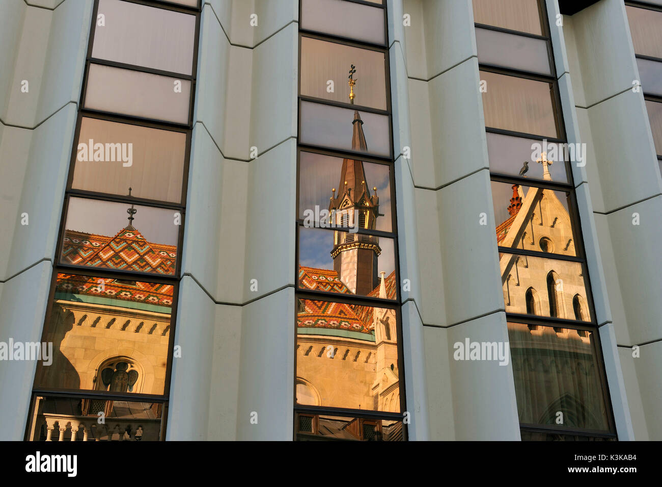 Ungheria, Budapest, quartiere Buda, Chiesa di Mathias riflettendo su Hilton Hotel 's windows, la collina del castello sono classificati come patrimonio mondiale dall' UNESCO Foto Stock