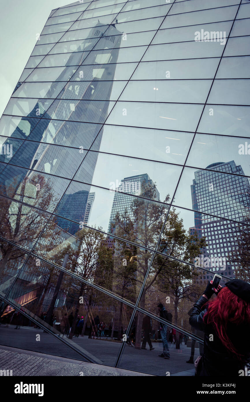 Capelli rossi Lady prende la foto del grattacielo la riflessione a livello nazionale 9/11 Memorial, il World Trade Center Memorial Foundation, Manhattan, New York New York, Stati Uniti d'America Foto Stock