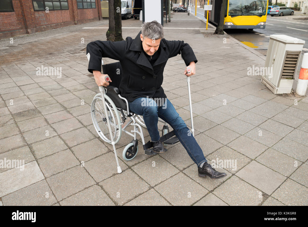 Disabilitato L'uomo cercando di camminare con l'aiuto stampelle Foto Stock