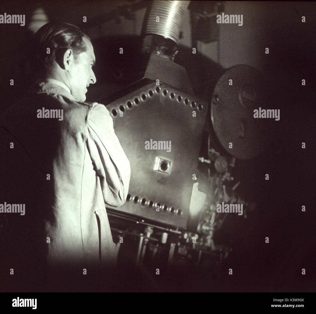 Unidentified protezionista in piedi da una Ross proiettore film c.1930s / 40s data: Foto Stock