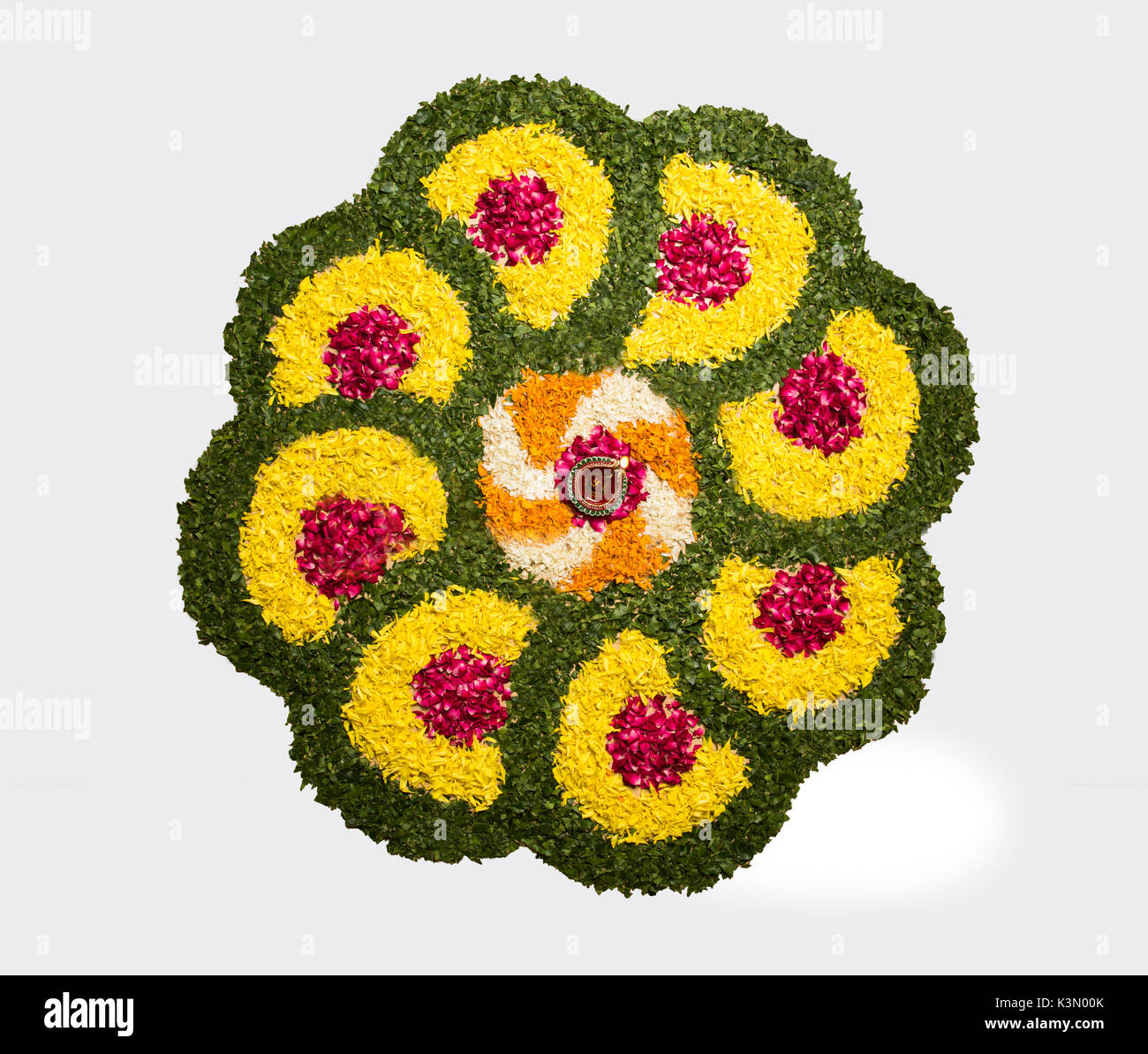 Flower rangoli di Diwali o pongal o onam realizzati utilizzando calendula o zendu fiori rosso e petali di rosa su sfondo bianco con diwali diya Foto Stock