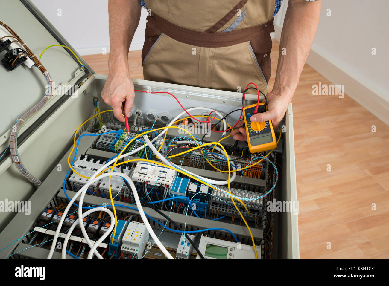 Close-up di un elettricista e controllare la scatola dei fusibili con il multimetro Foto Stock