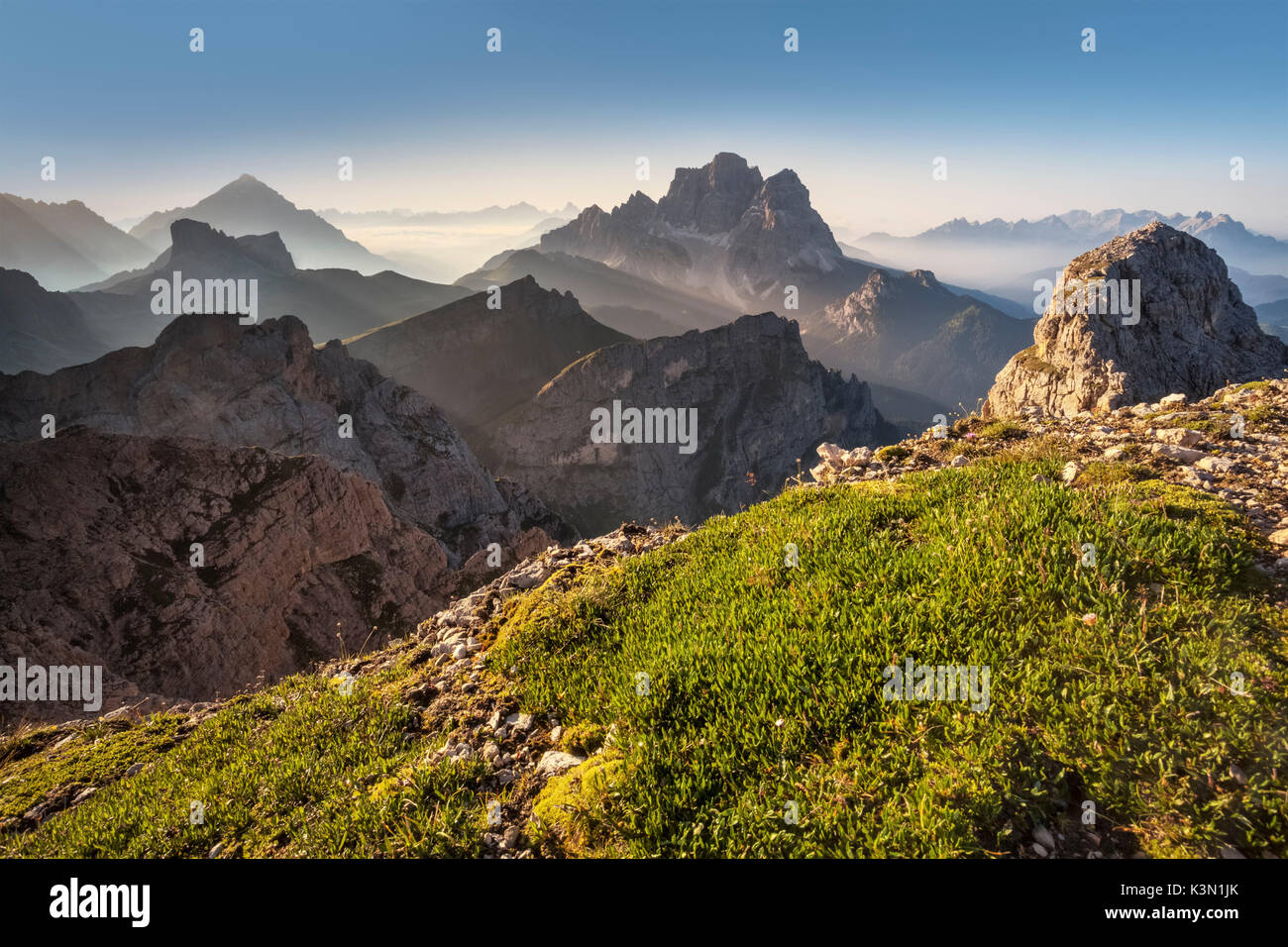 L'Europa, Italia, Veneto, Belluno. Raggi di luce dietro il Pelmo e Antelao, come si vede dal Monte Cernera, Dolomiti Foto Stock