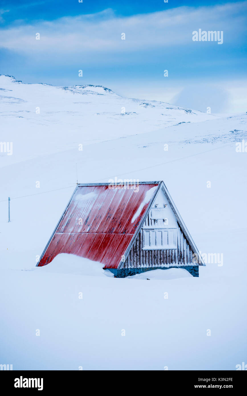 Penisola Snaefellsness, Western Islanda, l'Europa. Una piccola casa con tetto spiovente circondato dalla neve in inverno. Foto Stock